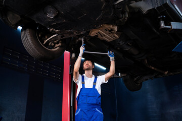 Professional mechanic working under the car Auto mechanic in auto repair shop, maintenance service