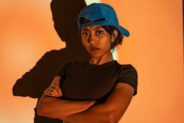 a multi-racial girl with a blue hat and a black T-shirt looking in the aggressive way with high attitude