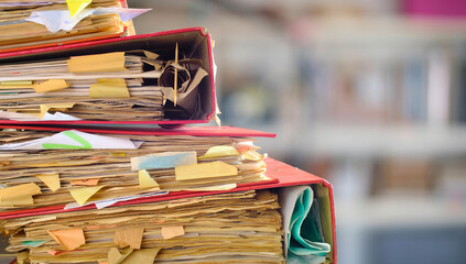 messy file folders,red tape, bureaucracy,aministration,business concept,isolated on blurred office...