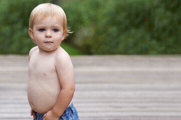 Baby, playing on porch outdoor for development with mockup, curiosity or early childhood in backyard of home. Toddler, child and relax in garden for wellness, milestone and exploring or innocent