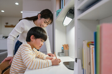 お母さんと一緒に家で勉強をしている小学生の男の子