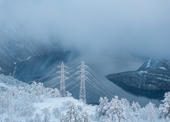 Power line in winter mountain, high voltage line over the mountain.