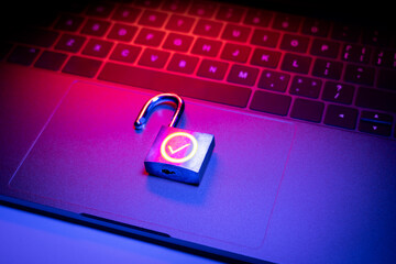 Closeup of a padlock lying on an computer surface. The padlock is unlocked and displays a green OK...