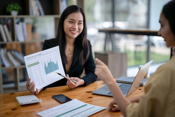 Two asian businesswoman accountants discuss financial management planning. Analysis of new startup...