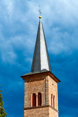 Fototapeta na wymiar Kirchturm der katholischen Kirche Karl Borromäus in Breuberg, Hessen 