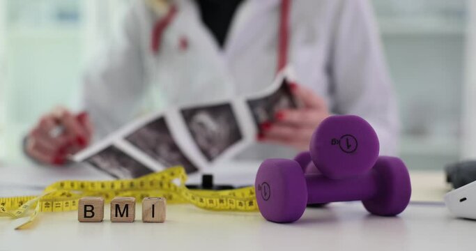 Cube with inscription BMI with dumbbells and measuring tape. Medical concept diet and health