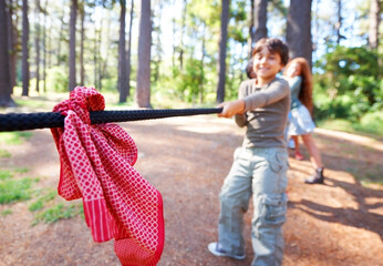 Kids, game and tug of war in forest at summer camp and holiday with travel and energy outdoor....