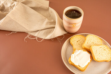 Toast with cream cheese and black coffee in a brown background in aerial view
