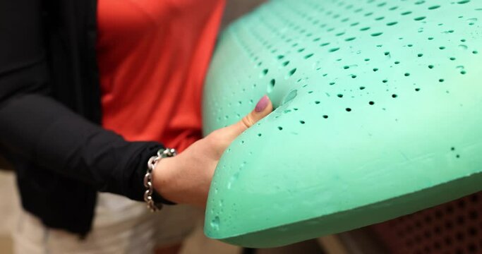Woman hand pressing on green memory foam pillow. Memory foam pillow concept