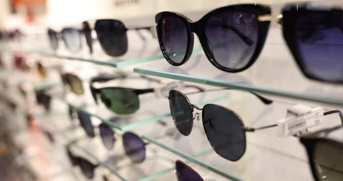 Many sunglasses on counter of optical store. Assortment of sunglasses.