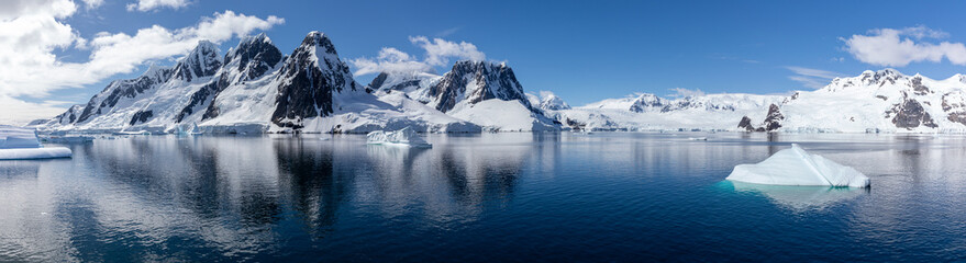 Panorama of Antarctica Landscape with high Rocky Mountains, icebergs, glaciers, clear water with a...