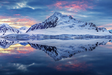 Antartica landscape with sea in the foreground and snow covered mountain in the background with...
