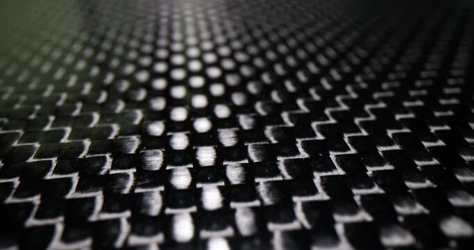 Black and white patterned carbon plate background closeup. Dark polyester fiber material and mesh black texture