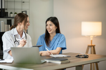 Obraz premium Female doctor sitting at work looking at the history of patients in the clinic or in the hospital