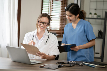 Female doctor sitting at work looking at the history of patients in the clinic or in the hospital