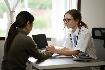 Female doctor sitting at work looking at the history of patients in the clinic or in the hospital