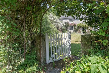 looking through an open gate to an old cottage in the garden
