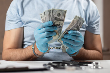 Doctor with handcuffs and money. Medical crime