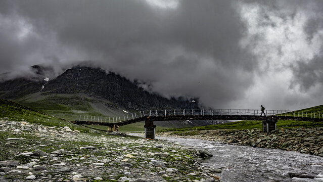 Mountain trail in Norway. Rainy weather in the mountains. Bridge on the trail in the Trollheimen mountains.