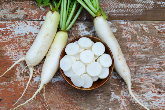 White Radish or mooli with sliced in a wooden bowl top view 