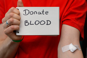 Dawca krwi trzyma kartkę z napisem oddaj krew