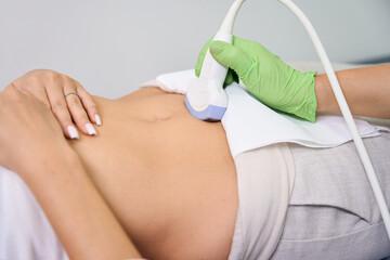 Cropped of female gynecologist doing ultrasound examination to pregnant woman