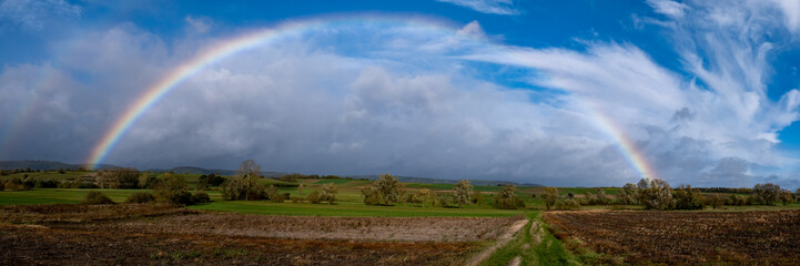 Arc-en-ciel au-dessus de champs en format panoramique