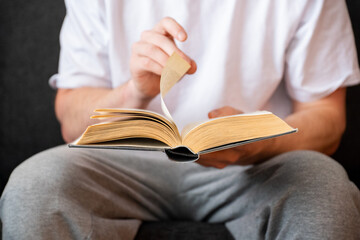 man sitting on couch and reading book