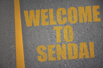 asphalt road with text welcome to Sendai near yellow line.