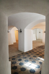 
A room with arched white walls and a checkered colored tiled floor