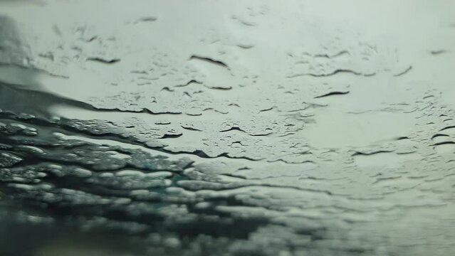 Rain drops hitting the car window seen from inside the car