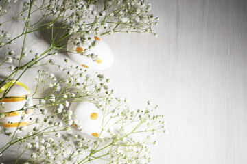 Easter eggs and spring flowers on a wooden background, top view, festive decoration, greeting card