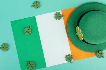 green irish leprechaun hat with shamrocks and irish flag on green background, saint patrick day...
