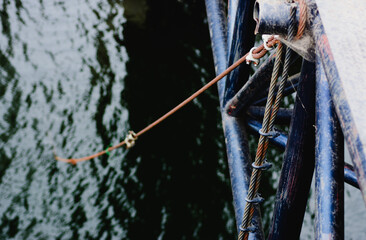 Naklejka premium Wire rope attach to railing of suspension bridge over the river.