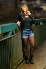 Young woman in her thirties photographed in portraits on a bridge with flash.