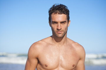 Man, portrait and beach for swimming, workout or outdoor exercise by the ocean coast in summer. Face of muscular male person or professional swimmer for on holiday weekend or vacation by the sea