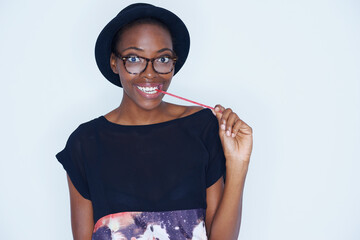 Portrait, fashion and black woman eating candy in studio on white background for sugar addiction....
