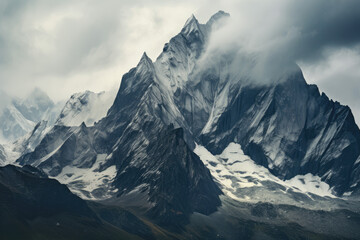 Obraz premium Beautiful mountain landscape with snow-capped peaks in the clouds