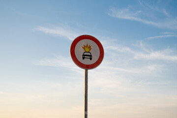 No entry for vehicles carrying explosive substances traffic sign, isolated sunset sky.