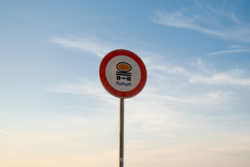 No entry for vehicles carrying water pollutive substances traffic sign, isolated sunset sky.