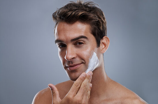 Portrait, shave cream and man with skincare, cosmetics and beauty on a grey studio background. Face, person and model with grooming routine and treatment with beard and moisture with wellness