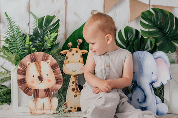 Happy two year old kid having his anniversary photoshooting in a studio. with jungle theme 