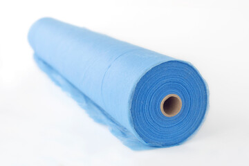 A roll of blue fabric, a sheet for massage, on a white background.