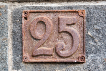 Old retro weathered cast iron plate with number 25