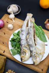 Dried fish in a plate with spicy on black background
