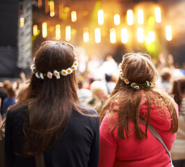 Women, friends and music festival in audience at outdoor concert, listening to live band. Female people, stage and watching entertainment in park for fun holiday weekend rave, vacation at party event
