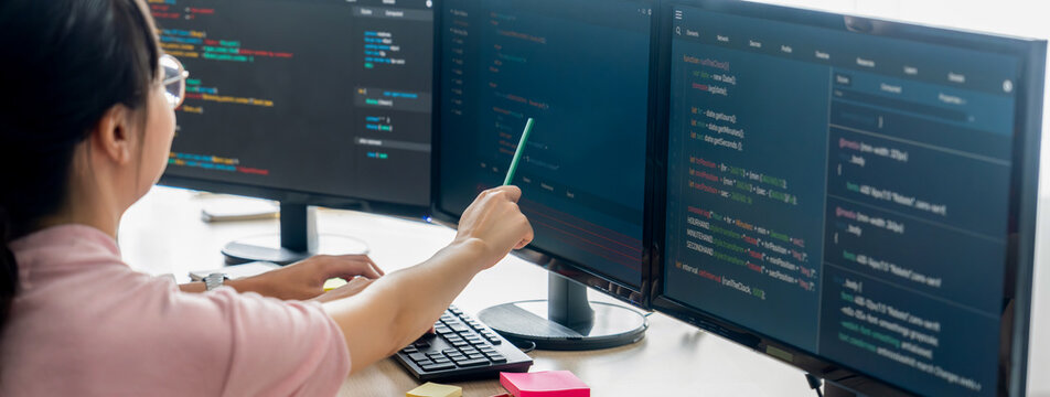 Female programer explain while pointing code displayed on computer. Professional programmer present data analysis and writing java script at modern company office. Closeup. Burgeoning.
