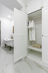 White coats hanging in a white wardrobe on white hangers