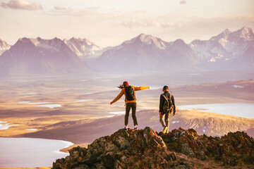 Young couple of hikers with backpacks is walking at mountain top with great view - Powered by Adobe