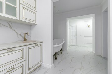 Freestanding bathtub bowl located in the hallway of the apartment, large mirror on the wall